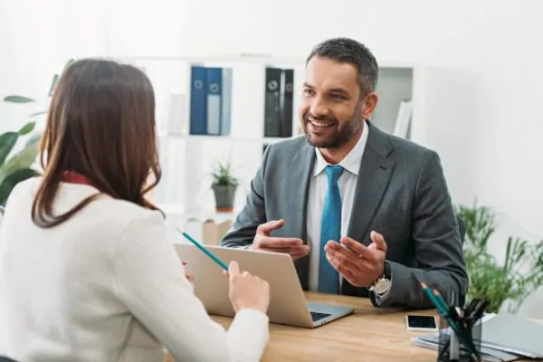 happy businessman chatting to a lady in an office